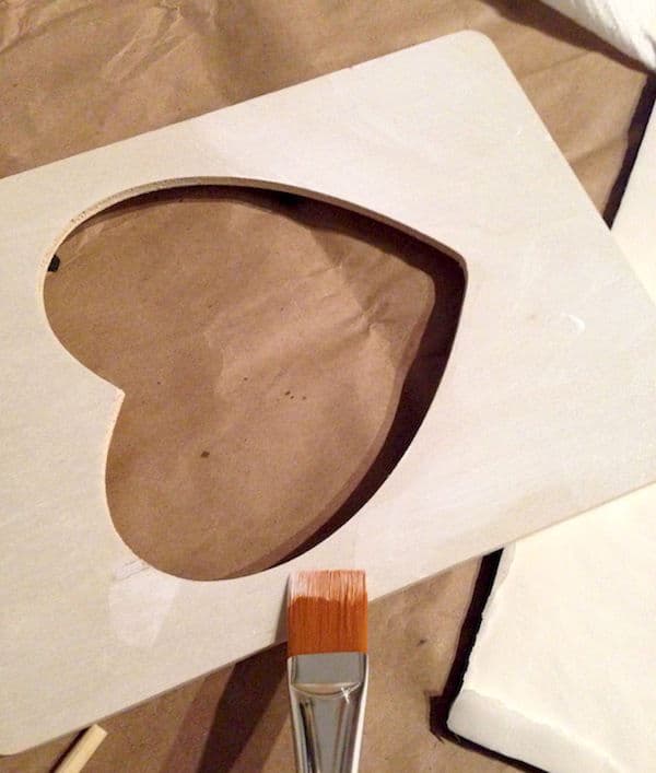 Painting the heart shaped frame with white craft paint