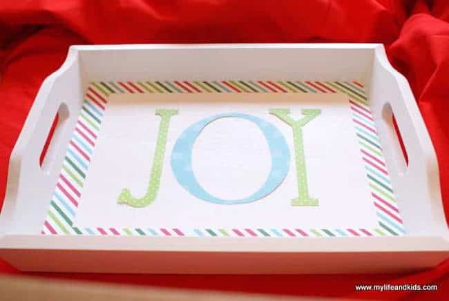 Paper letters forming JOY resting on the white tray