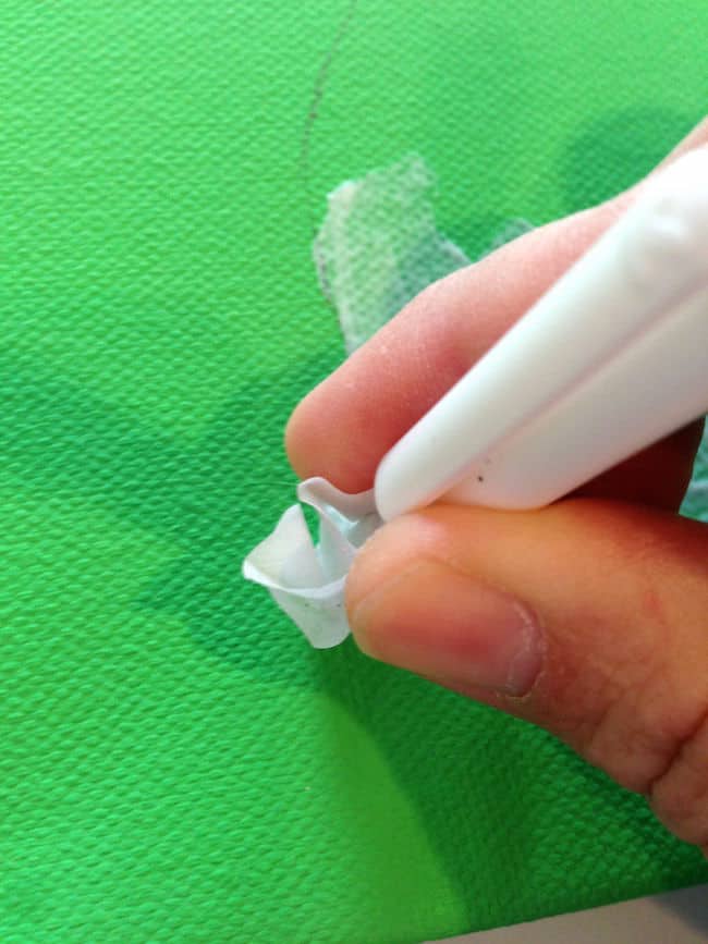 Inserting tissue paper into the moist Mod Podge on the canvas