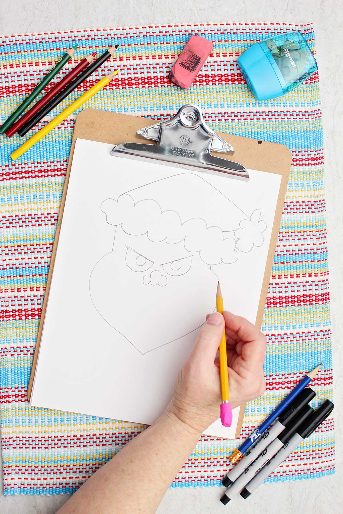 Individual adding eyes and a nose to their Grinch illustration.