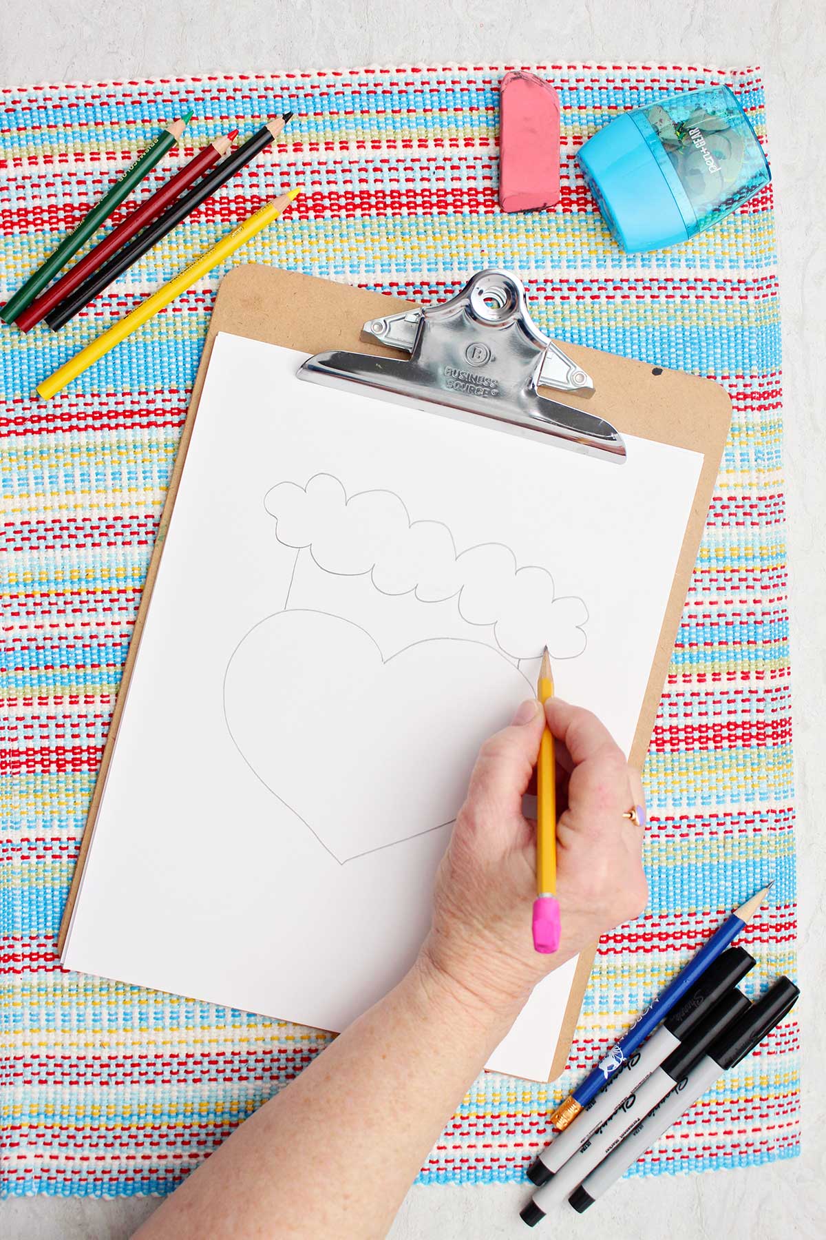 Individual adding some details to the Santa hat on their Grinch drawing.