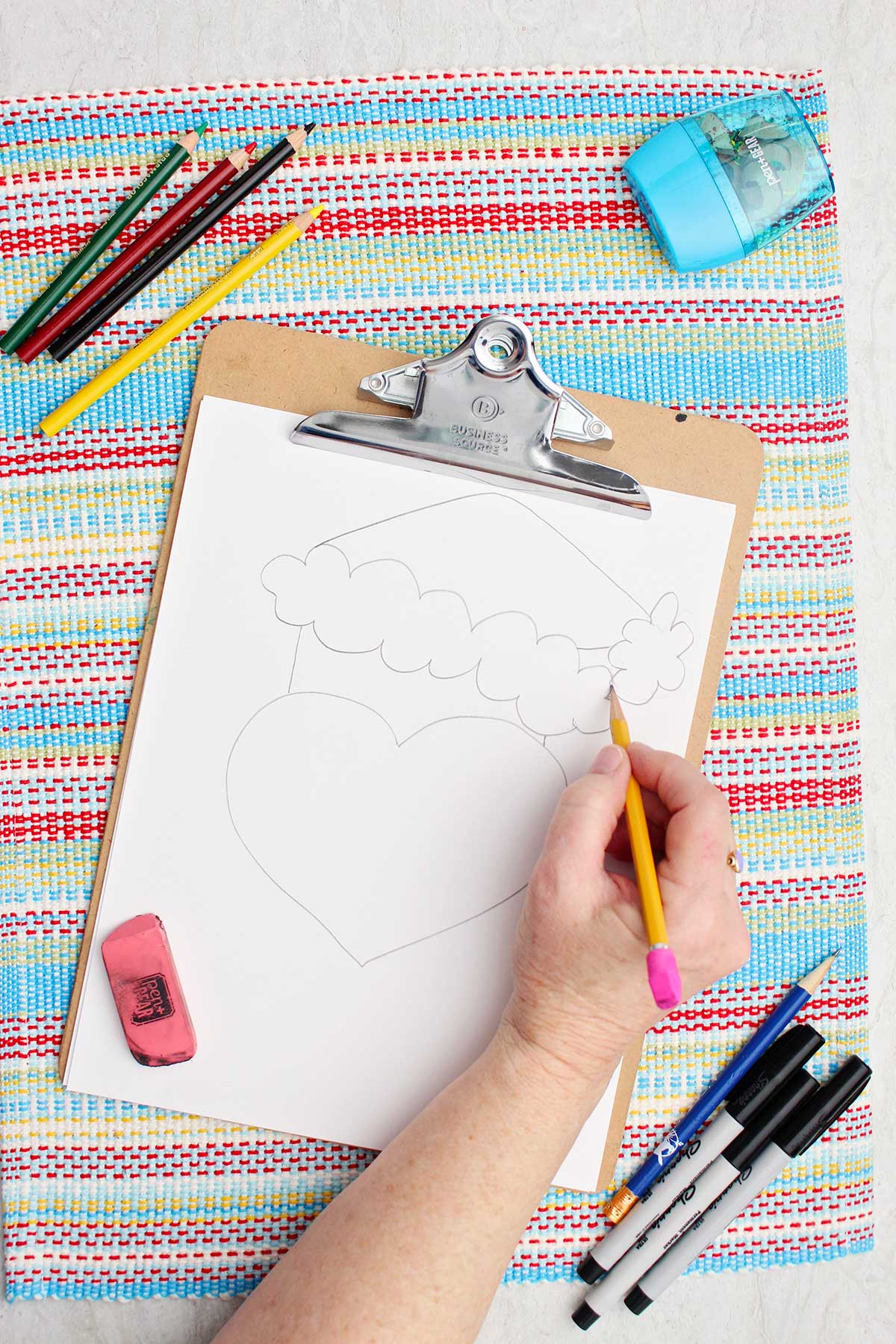 Individual adding some details to the Santa hat on their Grinch drawing.