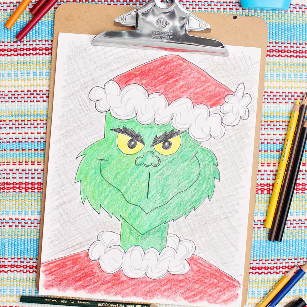 Colored version of a Grinch sketch with colored pencils nearby.