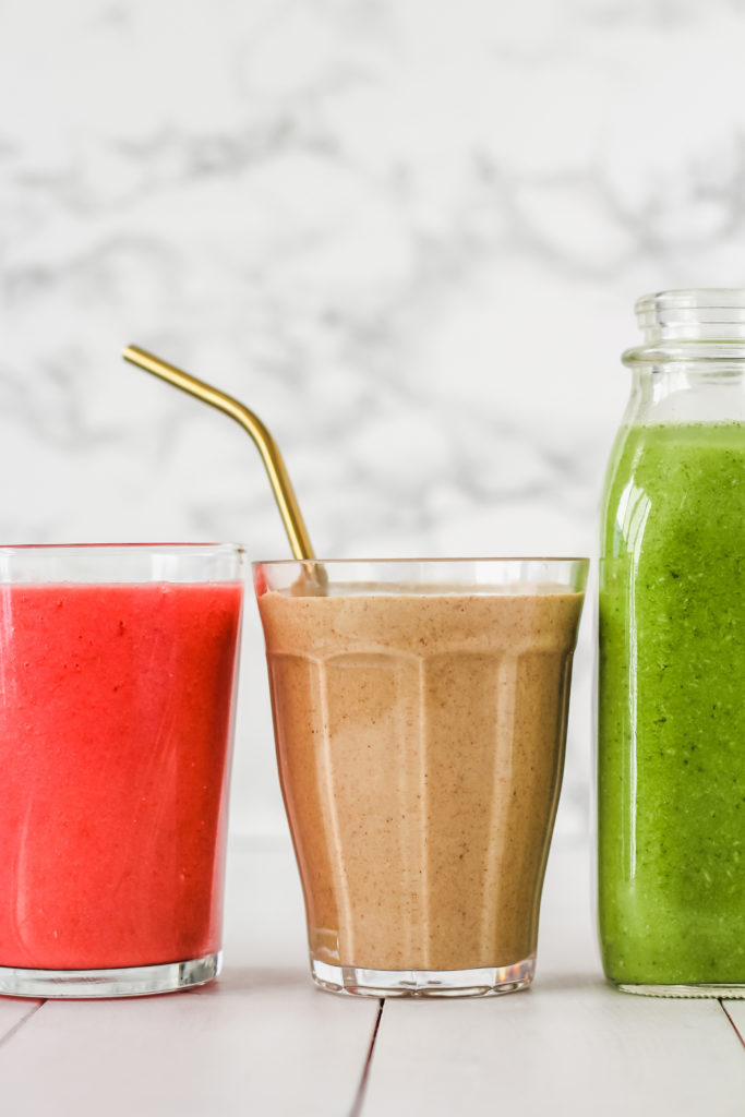 Cups of juice featuring a stainless steel straw.