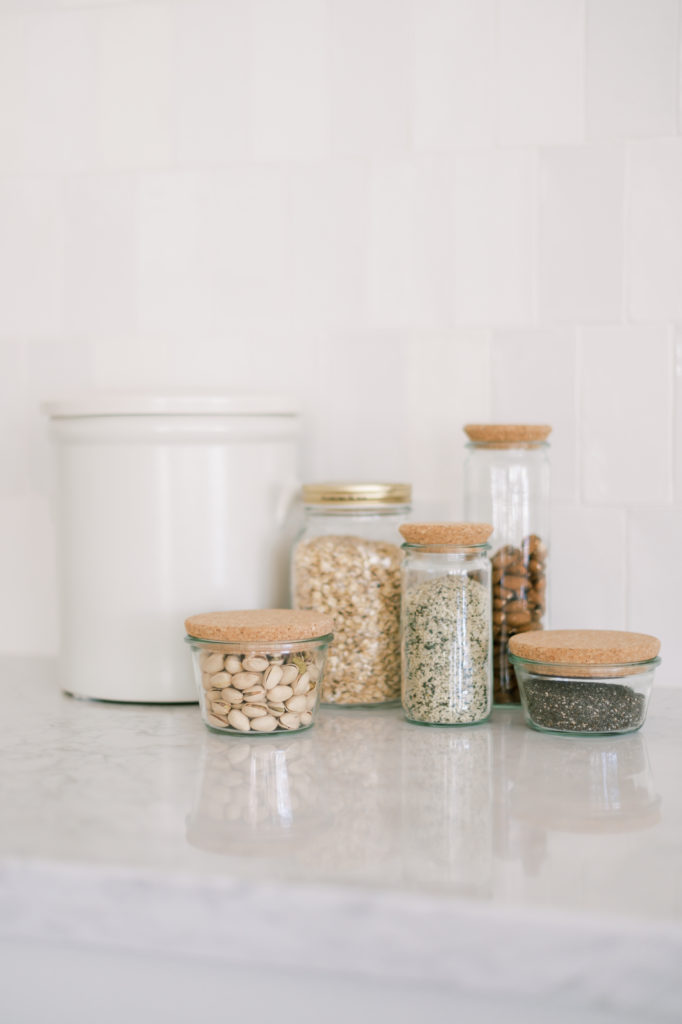 Glass containers filled with nuts, spices, and flour.