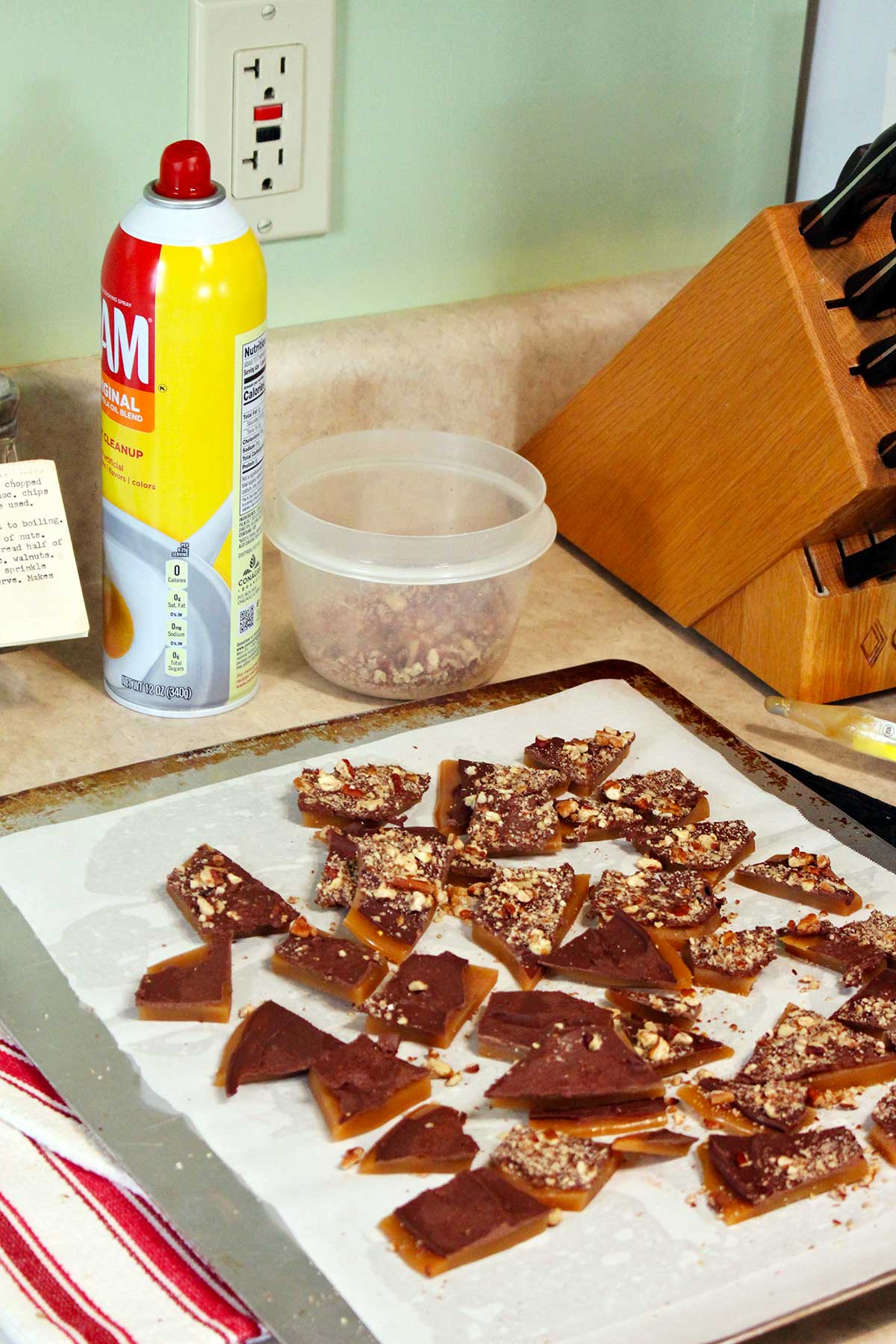 Broken pieces of toffee on parchment on the counter.