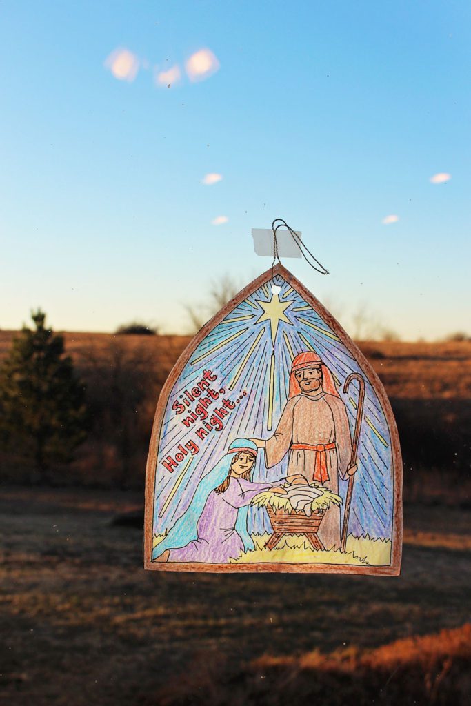 Finished Silent Night Christmas Coloring Page hanging on the window.