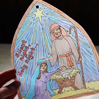 Finished Silent Night Christmas Coloring Page window decoration with light shining through.