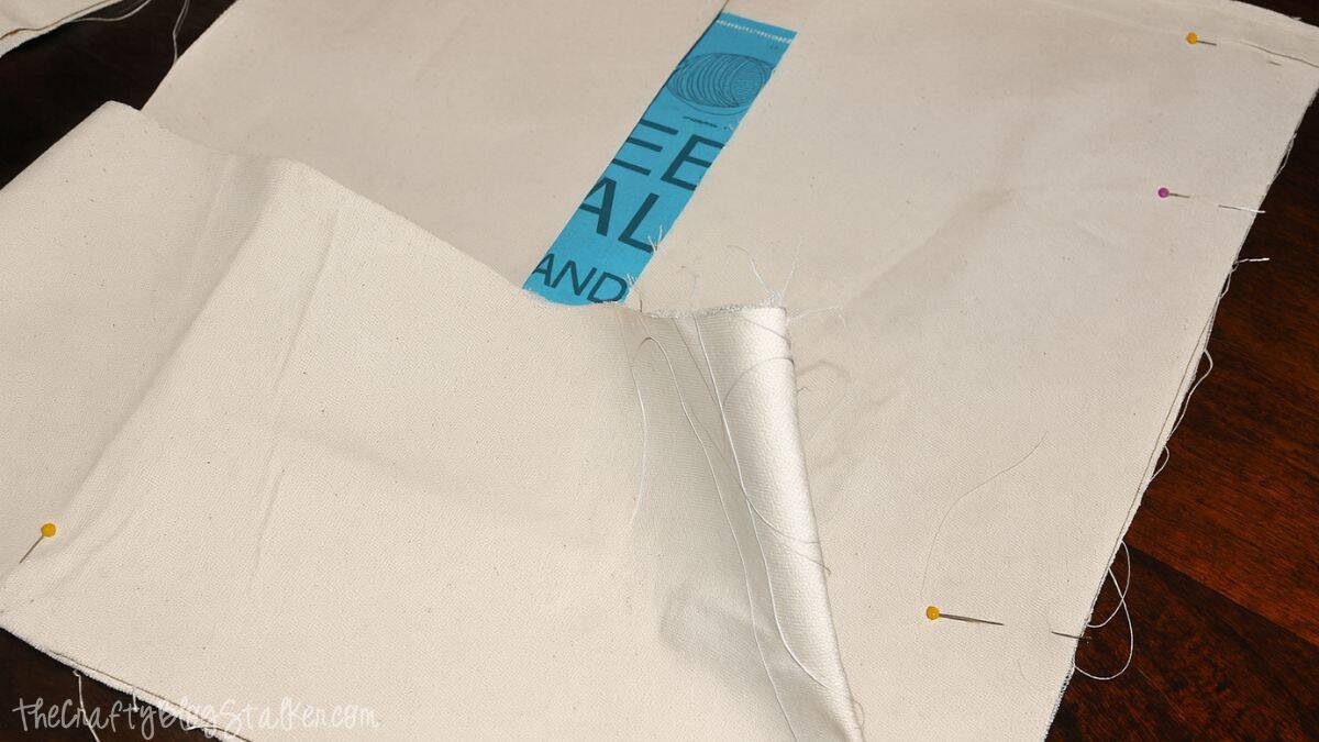 step 5 B Canvas tote bag panels pinned together along the sides and bottom while assembling a yarn project bag.