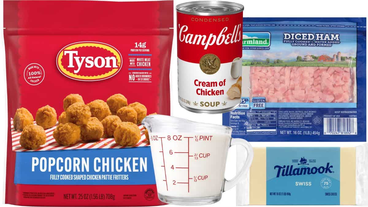 Ingredients for a chicken cordon bleu casserole, including popcorn chicken, diced ham, cream of chicken soup, Swiss cheese, and a measuring cup of milk.
