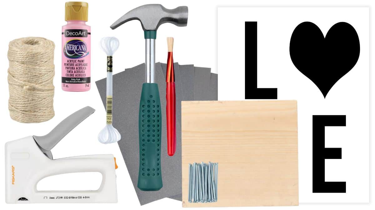 Materials for a DIY LOVE banner including twine, acrylic paint, hammer, nails, sandpaper, wood board, paintbrush, cotton swabs, hot glue gun, and stencil.