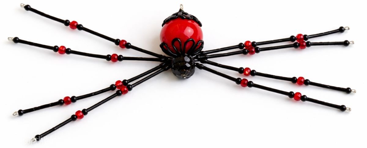 Fully assembled beaded spider craft with wire legs and bead body showcased flat on a simple background as a completed DIY decoration.
