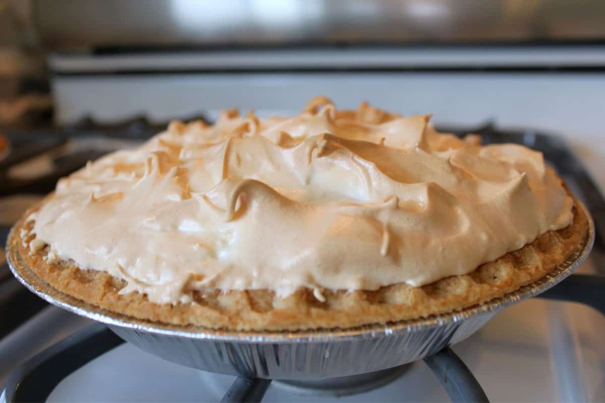 Lemon meringue pie displayed on a stove.