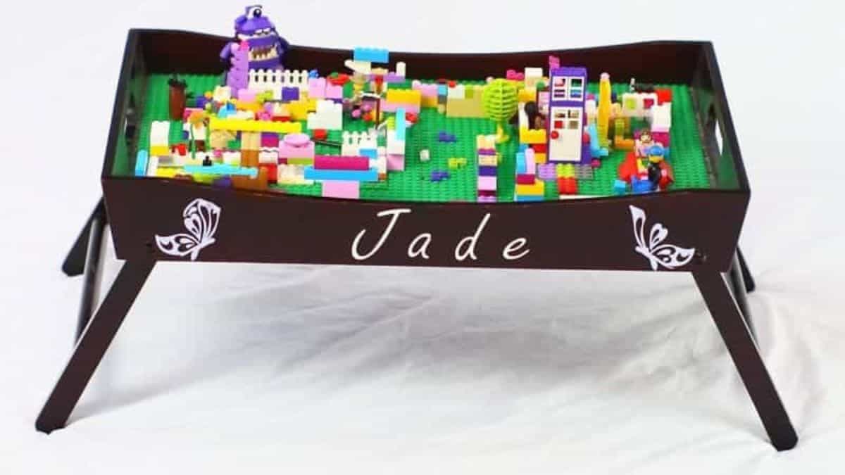 Customized LEGO play tray table filled with vibrant LEGO bricks and creations, featuring a raised border and the name Jade displayed prominently.
