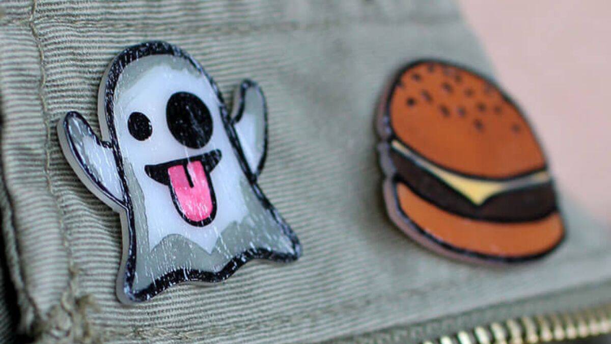 A close view of a fabric pouch with a zipper, featuring an adorable ghost patch and a cheeseburger patch sewn on the front.