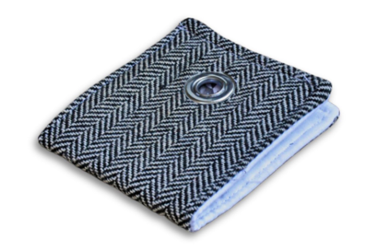 Compact fabric wallet in an elegant black-and-white herringbone pattern, displaying a central silver grommet accent and neatly stitched edges.