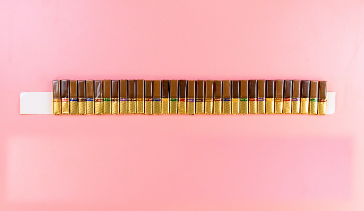 Chocolate bars side by side on a long piece of double-sided tape.