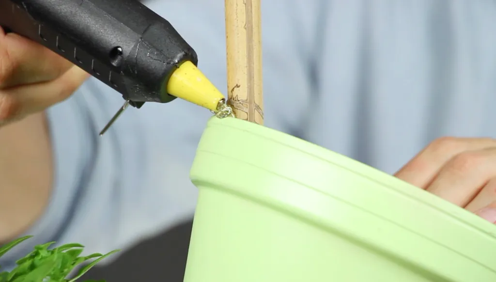A flower pot tower is secured using hot glue.