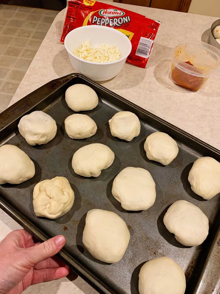 freshly made pizza pockets on a baking tray.