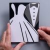 Hands holding a handmade wedding card featuring a white bride