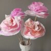 drei Papierrosen, gebastelt aus Küchenpapier, stehen in einer Vase